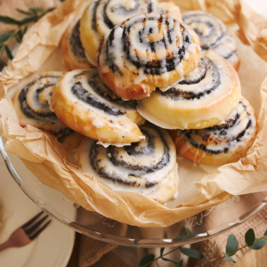 picture of cinnamon roll cookies piled on a plate with a cream cheese frosting glaze