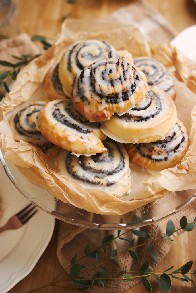 picture of cinnamon roll cookies piled on a plate with a cream cheese frosting glaze
